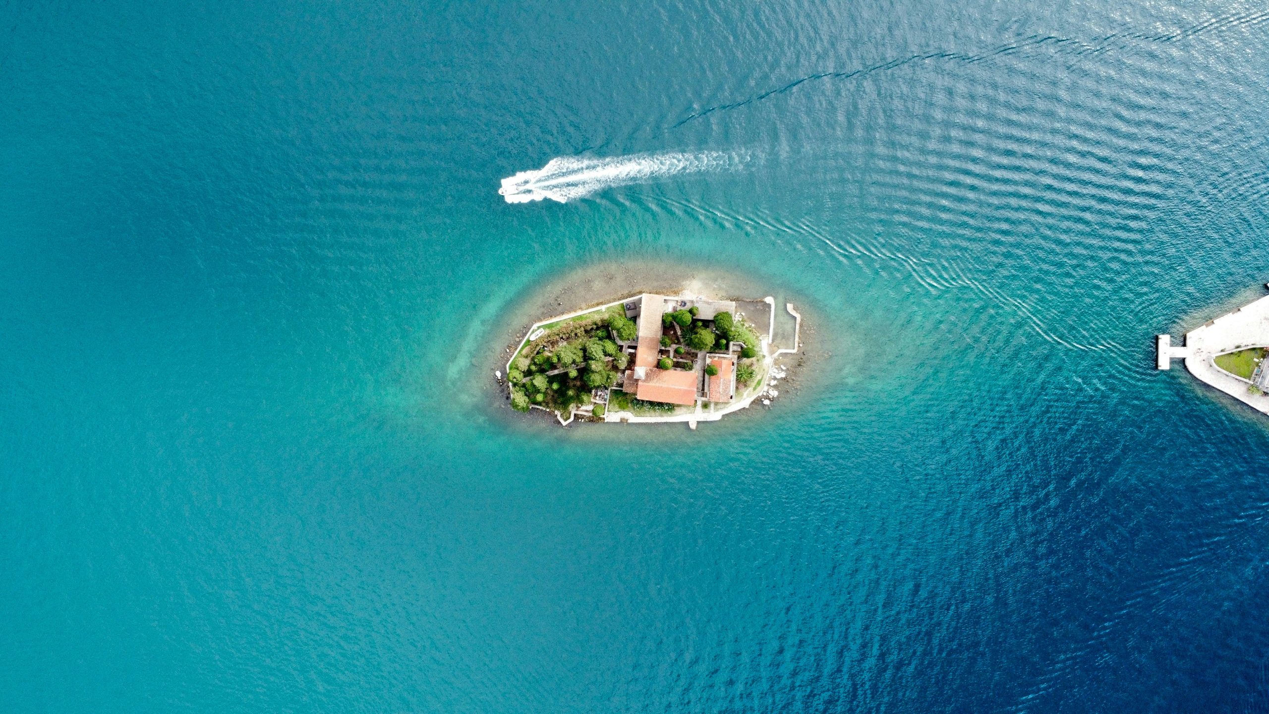Vedere aeriana a unei insule inconjurata de apa turcoaz, simbol al conceptului Insula iubirii si al strategiei de brand
